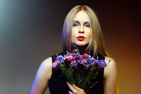 Skjønnhetskvinne med mange blomster. Profesjonell sminke og frisyre – stockfoto
