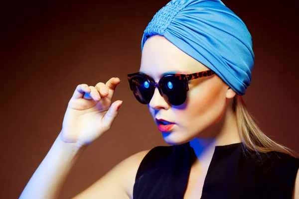 Mujer de moda en gafas de sol, tiro al estudio. Maquillaje profesional y peinado — Foto de Stock