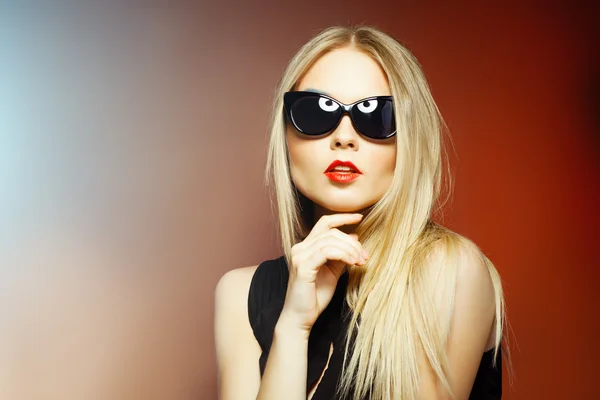 Mujer de moda en gafas de sol, tiro al estudio. Maquillaje profesional y peinado —  Fotos de Stock