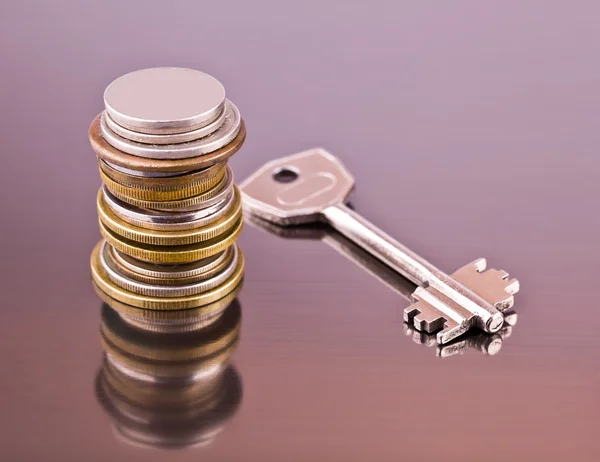 Stack of coins and key — Stock Photo, Image