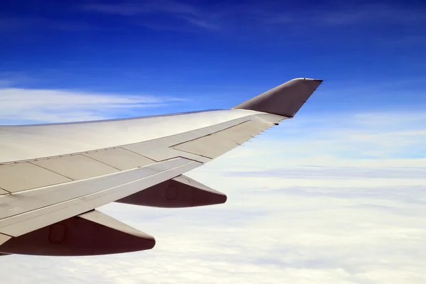 Blå himmel och flygplan wing som tittar på ett plan — Stockfoto
