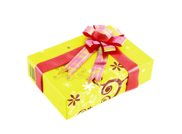 Żółte pudełko z czerwoną wstążką na białym tle — Zdjęcie stockowe