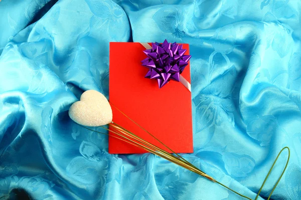 Tarjeta de regalo roja con cinta en satén azul — Foto de Stock