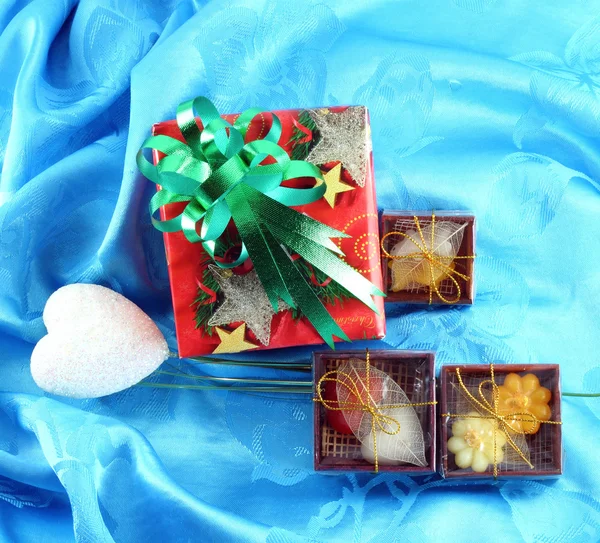 Red gift box set with green ribbon on blue satin — Stock Photo, Image