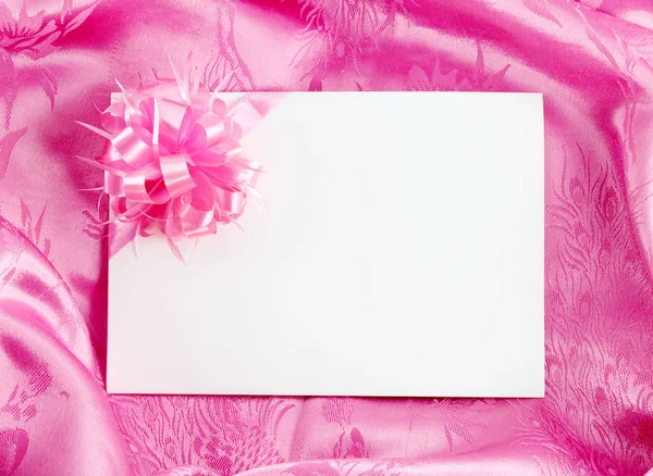 Blank gift card with ribbon on pink satin — Stock Photo, Image