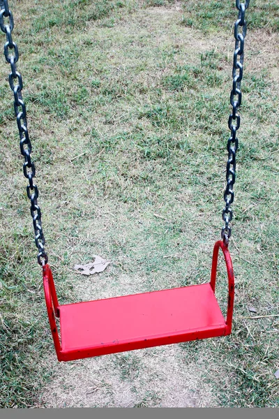 Red garden swing hanging in garden — Stock Photo, Image