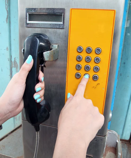 Donne mano componendo su un telefono pubblico — Foto Stock