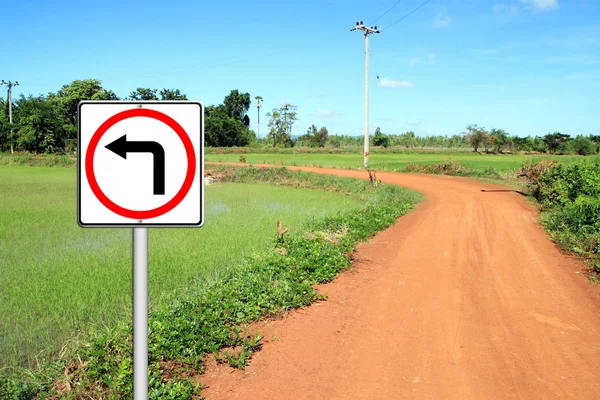 Turn left sign with soil road — Stock Photo, Image