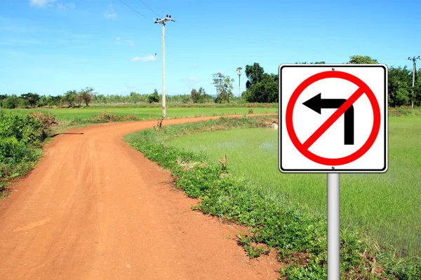 Don 't turn left sign with a left curved soil road — стоковое фото