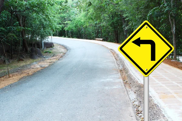 Vire à esquerda sinal de aviso na curva estrada — Fotografia de Stock