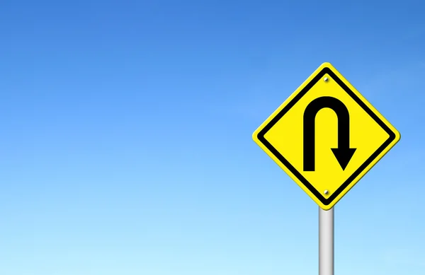 Yellow warning sign u-turn roadsign with blue sky background — Stock Photo, Image