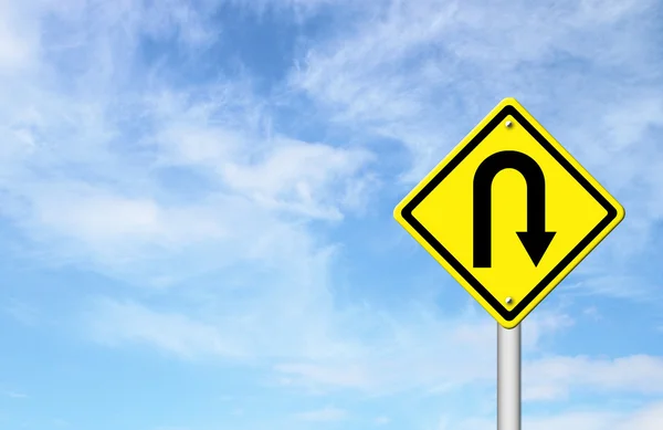 Yellow warning sign u-turn roadsign with blue sky background — Stock Photo, Image