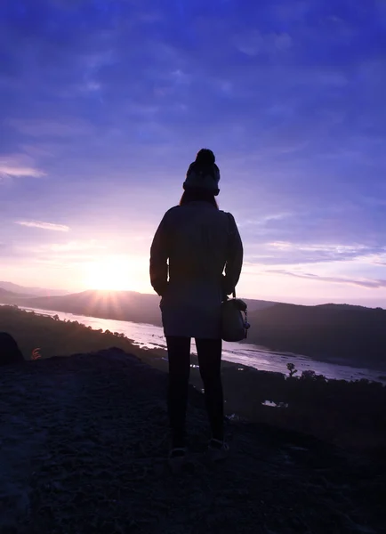 Femme est debout sur la falaise silhouette au lever du soleil — Photo