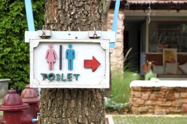 Letrero de baño en el árbol —  Fotos de Stock