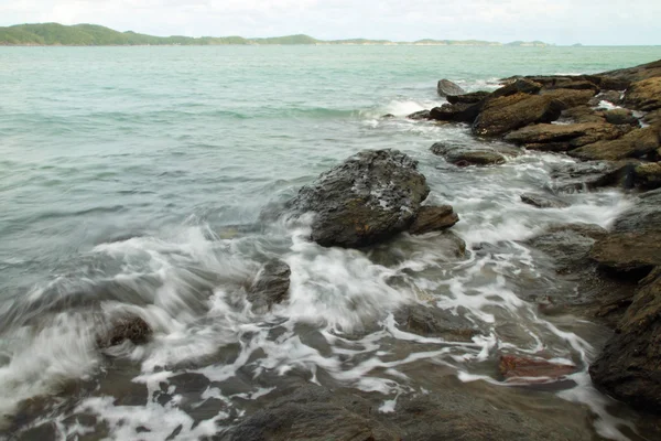 Sea waves hitting round rocks and splashing — Stock Photo, Image