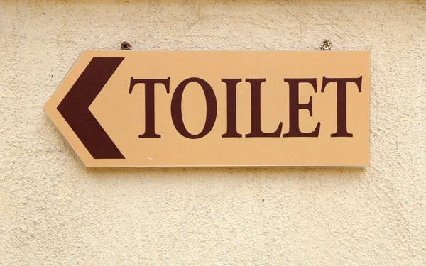 Туалетная табличка на стене — стоковое фото