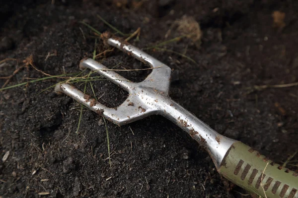 Close-up of small gardening fork on soil — Stock Photo, Image