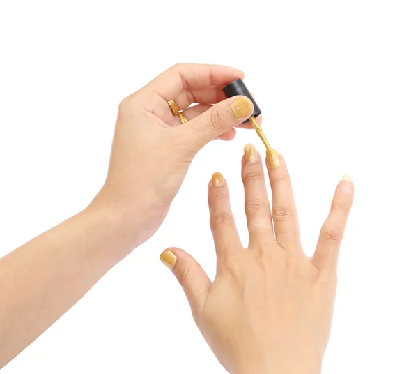 Mão feminina com um esmalte dourado no fundo branco — Fotografia de Stock