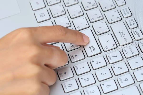 Finger pushing the button of keyboard Stock Photo