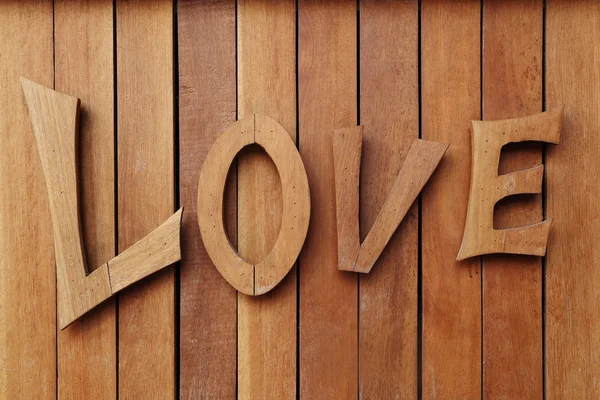 Láska dřevěné text na dřevěné stěně obrazce — Stock fotografie