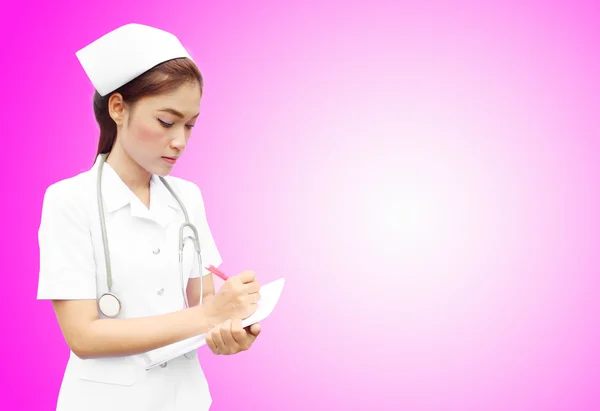 Asian female nurse writing medical report — Stock Photo, Image