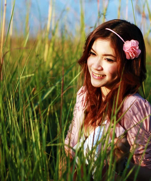 Portrait of beautiful young Asian girl in the grass — Stock Photo, Image