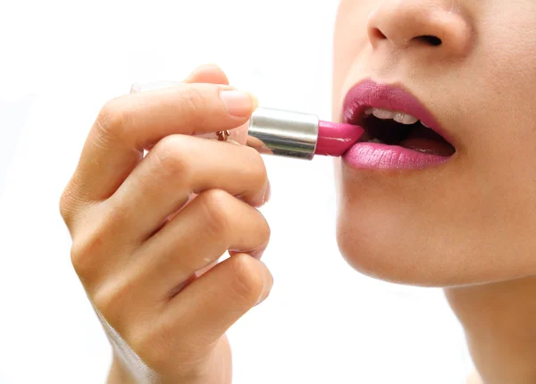Mooie vrouw is de toepassing van haar lippen met roze lippenstift — Stockfoto