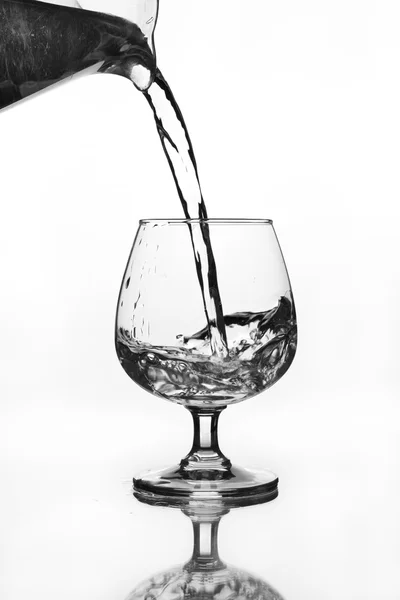 Water jug pouring to wine glass — Stock Photo, Image