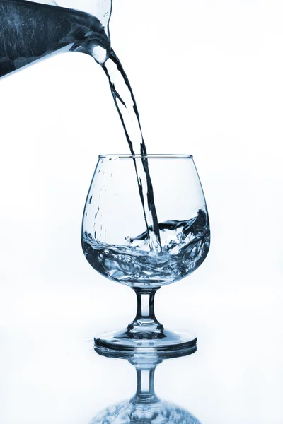 Waterkaraf gieten aan wijn glas — Stockfoto