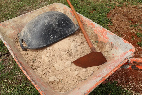 Old wheelbarrow with sand and equipment — Stock Photo, Image