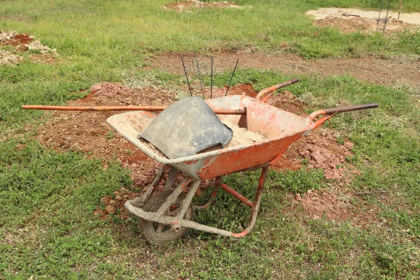 Old wheelbarrow with sand and equipment — Stock Photo, Image