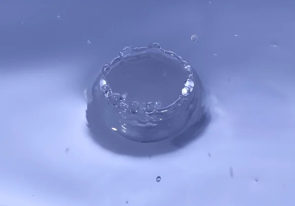 Salpicos de água com uma gota de água — Fotografia de Stock