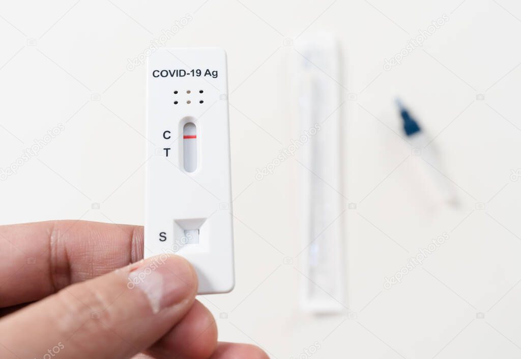 hand with Coronavirus(Covid-19) negative test result with SARS-CoV-2 Antigen Rapid Test kits for Self testing at home