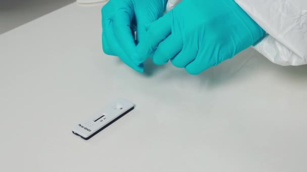 医生将液体样品的滴注转移到考罗奈德19号病毒的盒式磁带上进行检测 — 图库视频影像