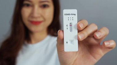 Coronavirus 'u (Covid-19) elinde tutan mutlu kadın antijen hızlı test kiti (ATK)