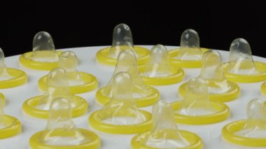 Tabakta dönen bir prezervatif alıyorum.