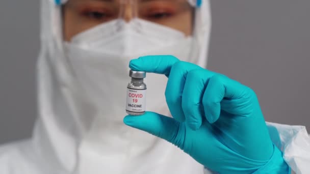 Lekarz Ochronnym Kombinezonie Ochronnym Trzymający Delikatnie Wstrząsający Butelką Szczepionki Coronavirus — Wideo stockowe