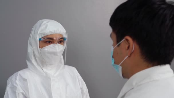 赤外線温度計を使用して保護Ppeスーツの医師は 人々と温度を測定します — ストック動画