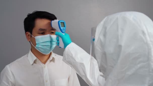 Nsanlarda Kızılötesi Termometre Kullanarak Koruyucu Ppe Giysisi Giyen Doktor Termoscan — Stok video
