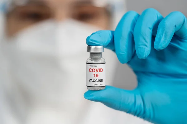 Medico Custodia Protettiva Della Tuta Ppe Agitando Delicatamente Flacone Vaccino — Foto Stock