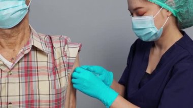 doctor make injection Covid-19 or coronavirus vaccine to senior patient in medical mask