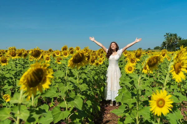 ひまわり畑で腕を上げて楽しむ陽気な女 — ストック写真