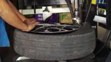 mechanic man removing tire from rim with tire removal machinery equipment