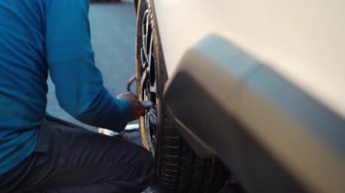 slow-motion hand of mechanic man to tightening the bolts of vehicle wheel for install a new car tire