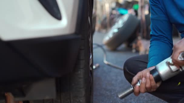 電気ドリルを使用して車のタイヤを交換するための車輪のボルトを緩めます — ストック動画