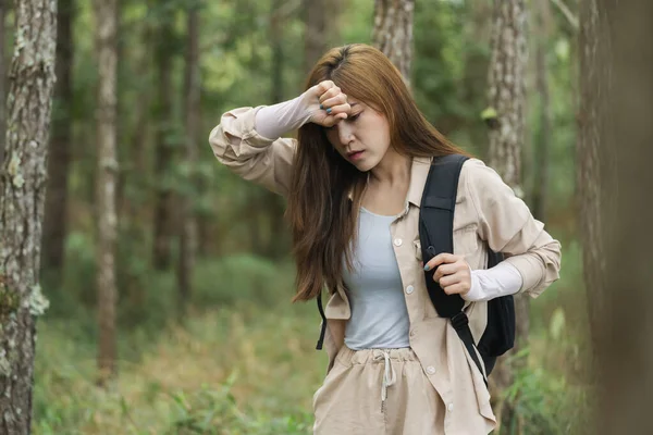疲れた女がリュックを背負ったまま森の中を歩き — ストック写真