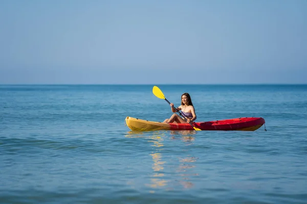 海でカヤックを漕ぐ水着姿の女性は — ストック写真