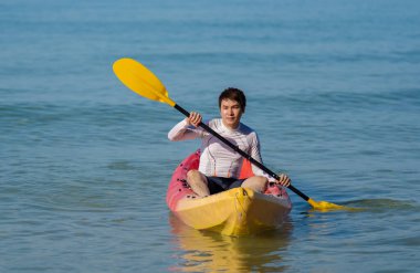 Denizde kano süren bir adam.