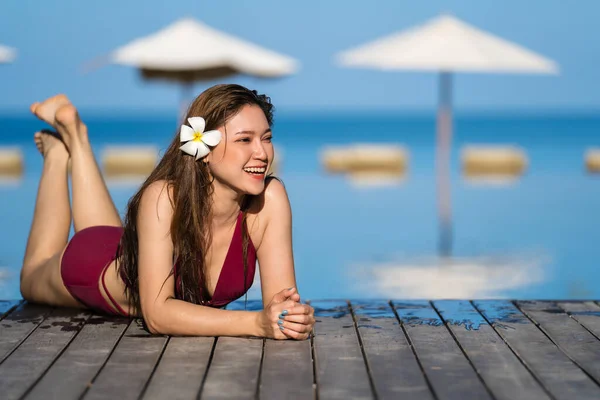 海を背景にプールの端でリラックスした水着の若い女性 — ストック写真