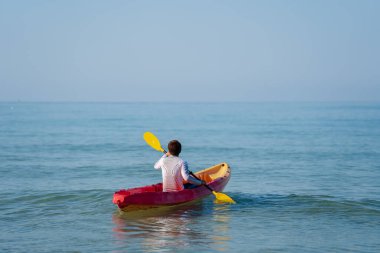 Denizde kano süren bir adam.